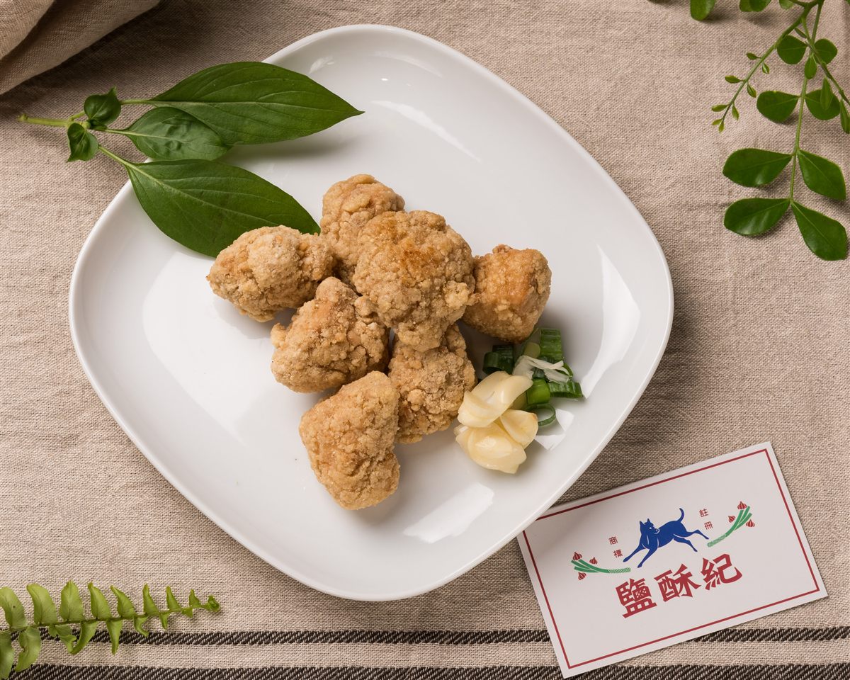 招牌無骨鹽酥雞，白盤上配九層塔與蒜片
