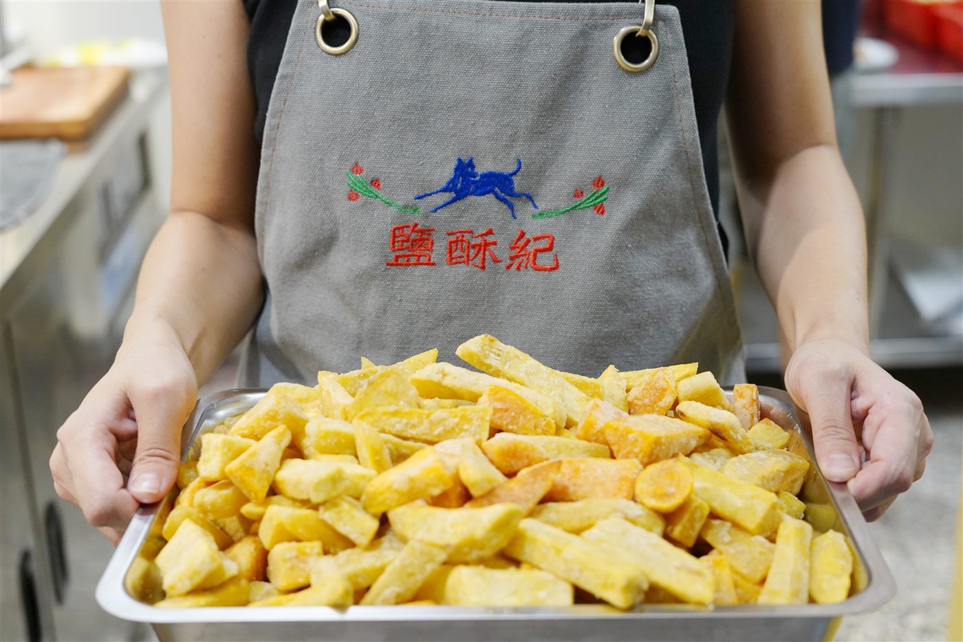 店員端著一盤剛起鍋的炸物